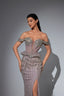 Woman wearing a sparkling off-shoulder evening gown against a gray background